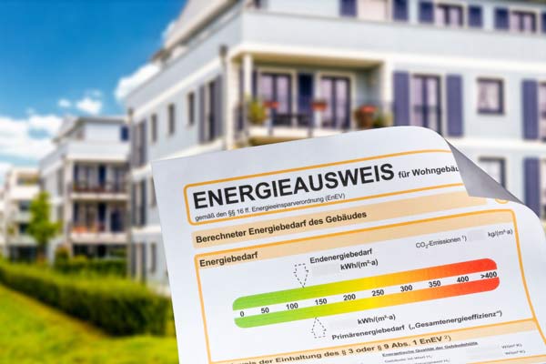 Energieausweis mit Mehrfamilienhäusern im Hintergrund